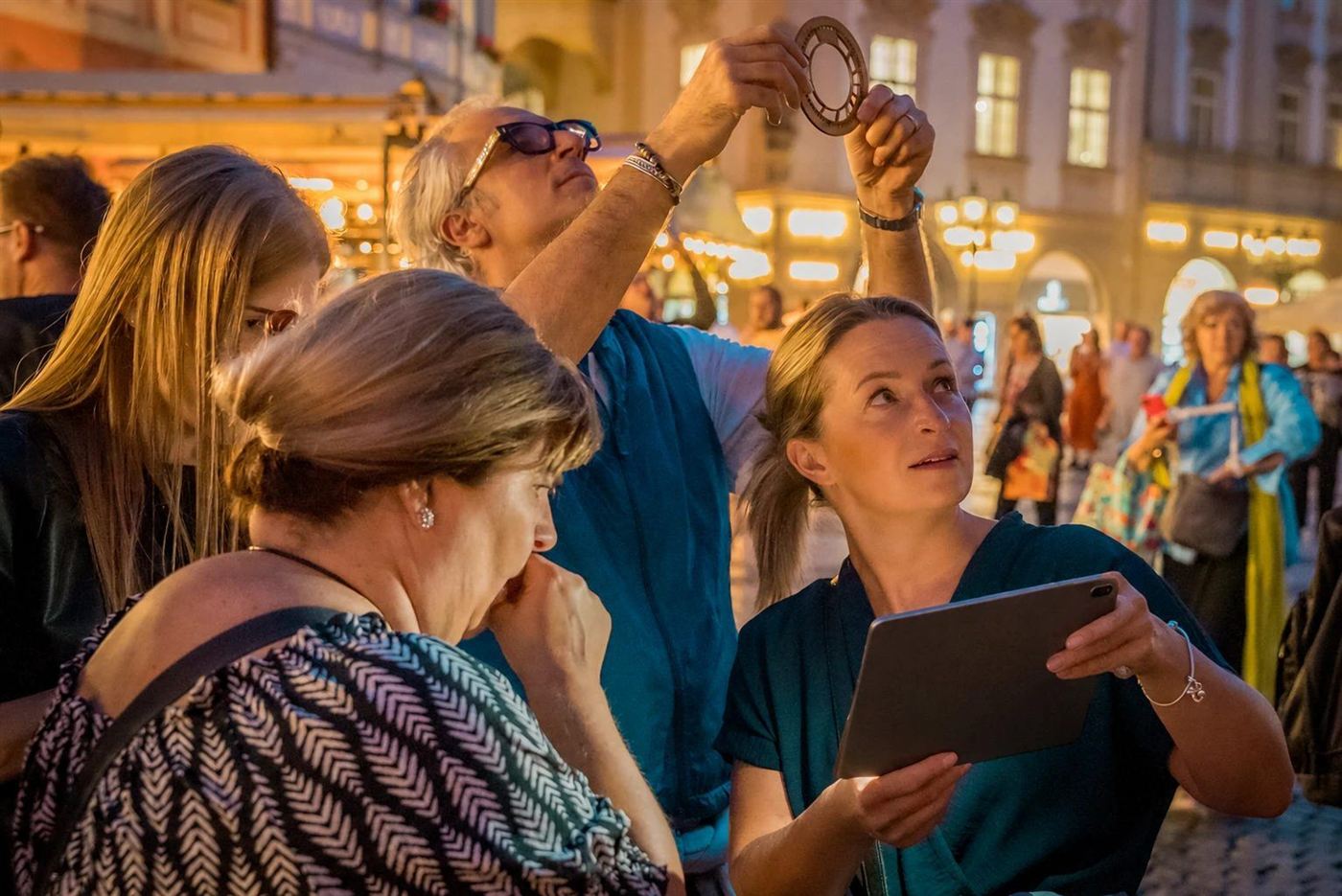 A team checks the zodiac wheel against the Astronomical Clock at dusk