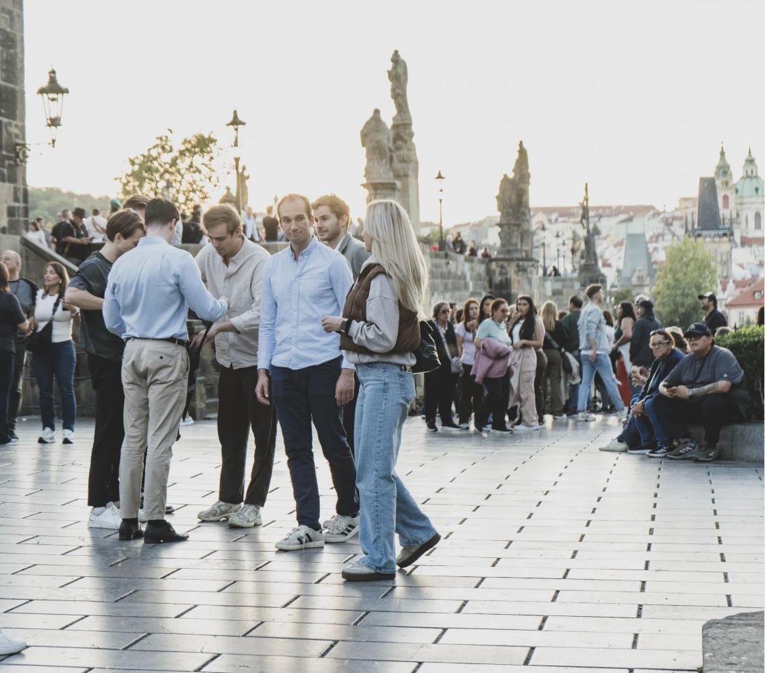 A team solving a task at the Charles Bridge, Prague Castle in the distance