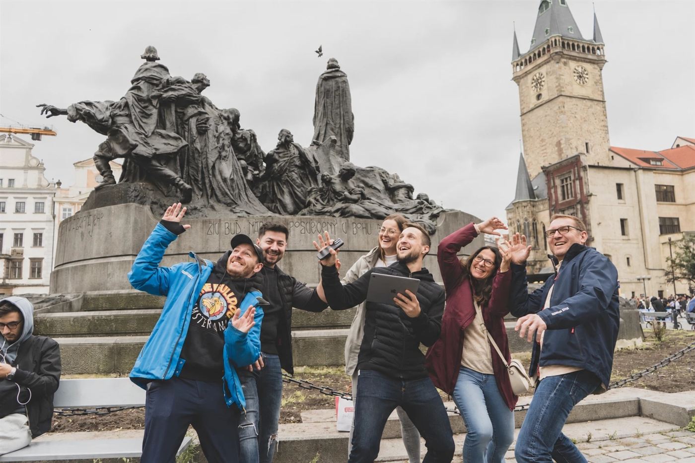 A team striking a pose at the Jan Hus Monument on Old Town Square
